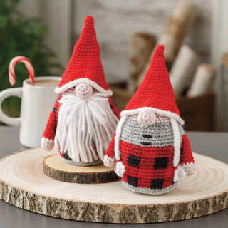 Two crochet gnomes on a wooden surface with a blurred background