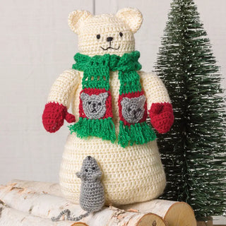 Crocheted bear with a green scarf, red mittens, and a small gray mouse on a white background.