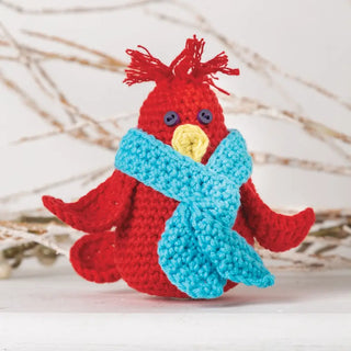 Crocheted red bird with a blue scarf on a light background