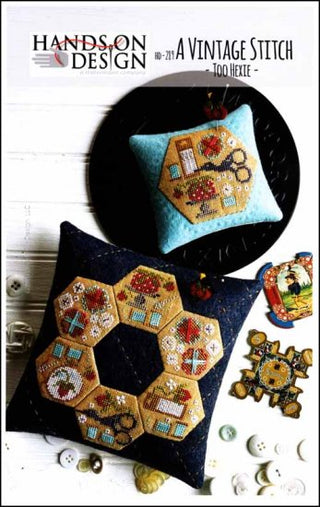 Cross-stitch design featuring multiple hexagon motifs filled with floral and geometric patterns, arranged in a patchwork-style layout and finished as decorative pincushions.