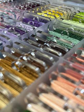 Close-up of colorful embroidery floss in clear containers