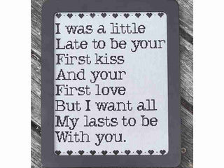 Decorative cross stitch design with romantic text and heart symbols on a wooden background