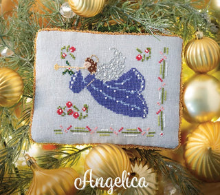 Decorative cross-stitched angel ornament on a Christmas tree with gold ornaments.