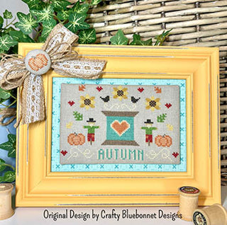 Cross-stitch design with teal thread spool, red heart, sunflowers, pumpkins, and scarecrows — autumn folk art by Crafty Bluebonnet Designs.