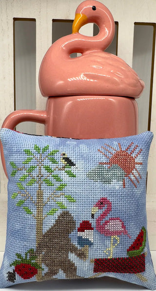 Cross Stitched pillow of bigfoot with ice cream, flamingo, watermelon, strawberry, sunshine with decorative flamingo mug.
