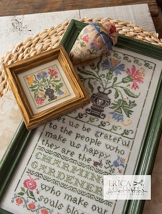 Cross-stitched pieces on a woven surface with 'Erica Michaels' branding.