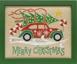 Cross-stitch design of a vintage green car decorated with snowflakes and peppermint swirls, carrying a Christmas tree on the roof with “Merry Christmas” stitched beneath — Stoney Creek Collection.