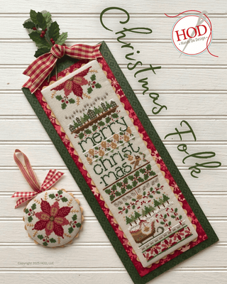 Christmas-themed cross-stitched design with decorative ribbons on a wooden surface, featuring the brand 'HOD'.