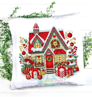 Decorative pillow with a Christmas-themed house design on a white background