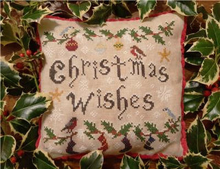Cross-stitched pillow with 'Christmas Wishes' text surrounded by holly leaves.