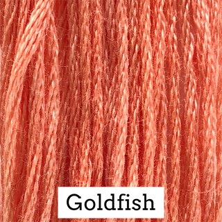 Close-up of coral-pink embroidery floss strands with a white label at the bottom reading 'Goldfish'.