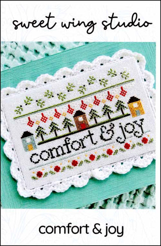 Cross-stitched design with 'comfort & joy' text on a white background with decorative border.
