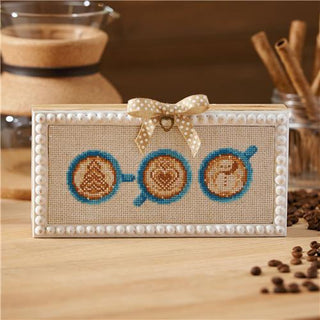 Decorative frame with coffee-themed design on a wooden surface with coffee beans.