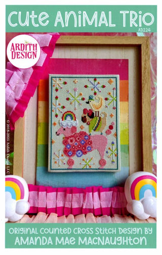 Colorful cross-stitch design featuring a stacked trio of whimsical animals — a pink poodle, a small dog in a green sweater with a red bow, and a cheerful yellow bird — surrounded by playful decorative motifs.