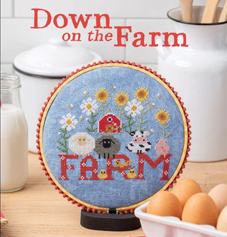 Cross-stitched design with farm animals and 'Farm' text on a wooden hoop, set against a kitchen background.