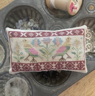 Dutch Birds cross stitch pattern by From the Heart NeedleArt by Wendy featuring a horizontal folk art design with stylized birds and floral motifs in a sampler-style band, finished as a decorative pillow.