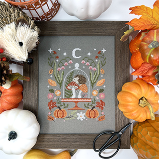 Decorative framed print with autumn-themed design surrounded by pumpkins and a hedgehog.