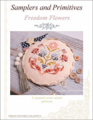 Cover of 'Samplers and Primitives Freedom Flowers' with a cross-stitched design and decorative elements.