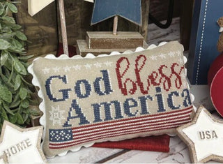 Decorative pillow with 'God bless America' text and American flag design.