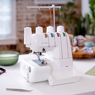 White sewing machine on a table with a blurred background