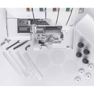 Close-up of a sewing machine with various components on a white background