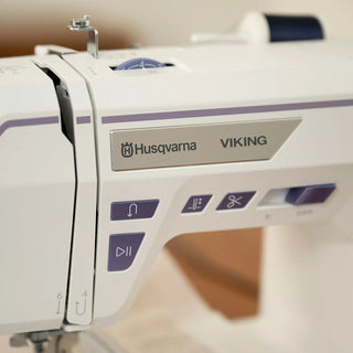Close-up of a Husqvarna Viking sewing machine with control panel.