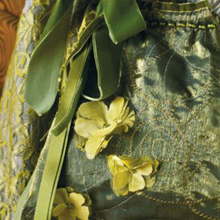 Close-up of a fabric with green leaves and yellow flowers on a textured background