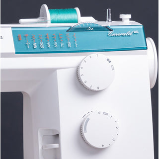 White sewing machine with teal top and thread spool on a dark background. EMERALD 116 – stitch selection dials close-up