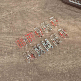 Set of sewing machine presser feet on a wooden surface