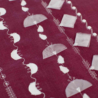 White embroidered patterns on a red fabric background