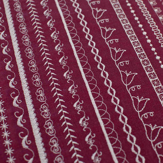 Close-up of a fabric with white embroidered patterns on a red background