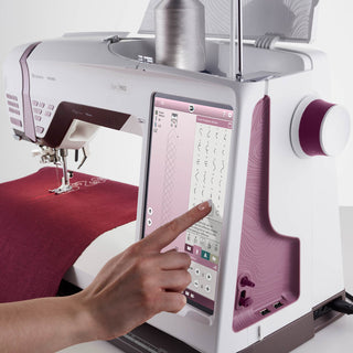 Sewing machine with digital display and hand interacting with it on a white background