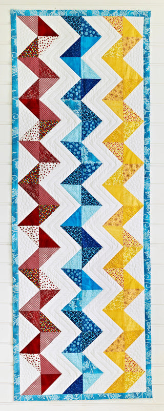 Colorful zigzag pattern quilt on a white background
