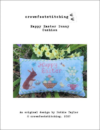 Cross-stitched Easter bunny cushion with floral design on a white background