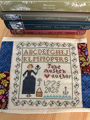 Jane Austen-themed cross stitch sampler with alphabet, silhouette figure, and Regency-style motifs by The Sampler Girl.