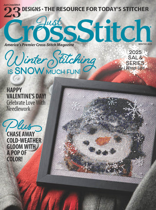 Magazine cover of 'Just Cross Stitch' featuring a snowman cross-stitch design.