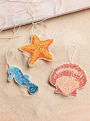 Just CrossStitch Magazine: 2025 Summer Edition. Seaside Suncatchers
Designs by Elizabeth Spurlock of Saving Graces Fine Needlearts
Stitched on clear perforated plastic canvas with soothing shades of floss and shimmering beads, these beach-themed suncatchers let the allure of summer shine all year round.