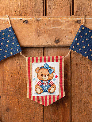 Just CrossStitch Magazine Summer 2025 Edition. Beary Patriotic Design by Jenny Barton of JB Cross Stitch. 
This adorable bear, draped in the stars and stripes, will bring a perfect blend of stitched charm and patriotic pride to your home's decor.