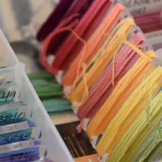 Colorful embroidery floss spools in a container