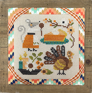 Cross-stitched pattern with a turkey and autumn elements on a wooden surface