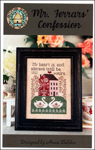 Framed cross-stitch art with romantic design and text, set against a decorative background.