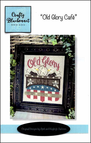 Decorative cross-stitch pattern with 'Old Glory' design in a black frame, featuring an American flag and text.