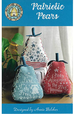 Three pear-shaped cross stitch designs with patriotic patterns and text including “Land of the Free” and “I Pledge Allegiance,” finished as decorative stuffed ornaments in red, white, and blue.