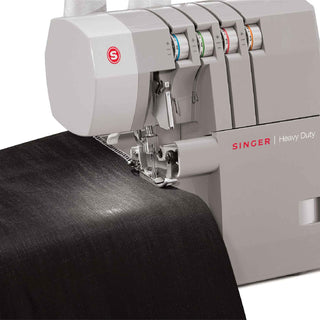 Singer heavy-duty sewing machine stitching black fabric on a white background