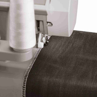 Sewing machine needle stitching a dark fabric