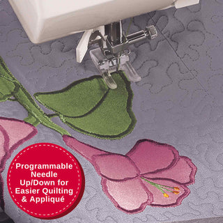 Sewing machine needle working on a floral quilt with a programmable needle feature highlighted.