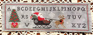 Cross stitch pattern featuring Santa on a sleigh pulled by a reindeer, surrounded by a Christmas alphabet border and festive details in red, green, and gold.