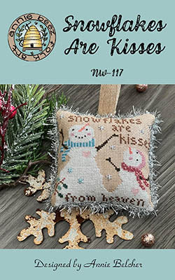 Cross stitch pattern depicting winter-themed elements, such as snowflakes and a snowman, with the text 'Snowflakes Are Kisses' displayed.