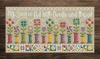 Cross stitch sampler featuring colorful thread spools blooming into flowers with the quote “My soul is fed with needle and thread” by Shannon Christine Designs