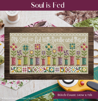 Cross stitch sampler featuring colorful thread spools blooming into flowers with the quote “My soul is fed with needle and thread” by Shannon Christine Designs